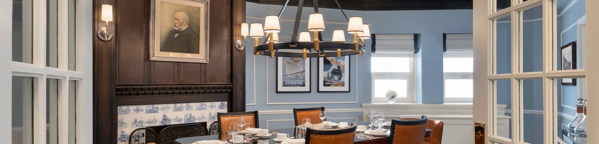 dinging room with pale blue walls and dark wood fireplace