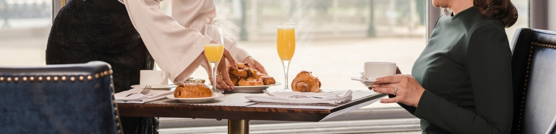 Woman serving another woman croissants