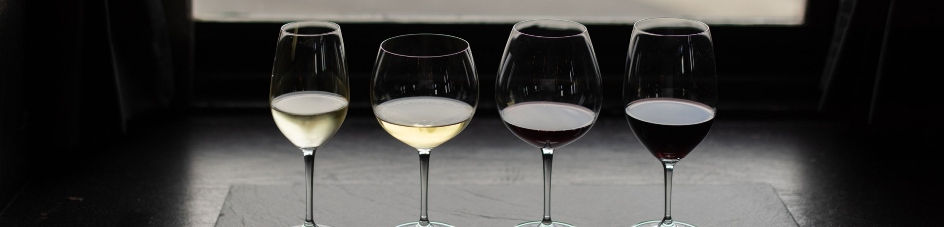 Array of wine glasses on a table in front of a window