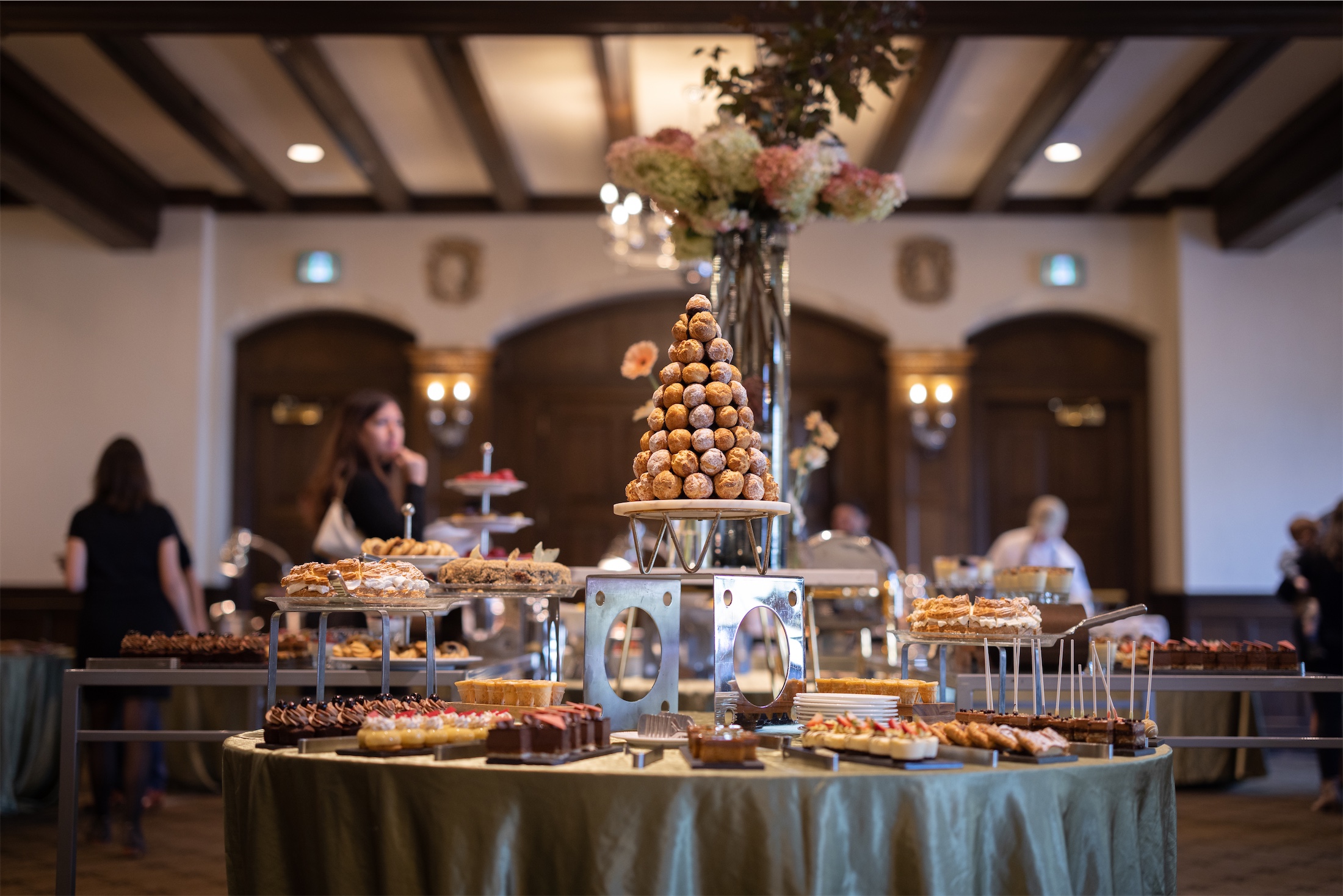 Christmas tree made of desserts surrounded by a buffet array of baked goods at Champlain