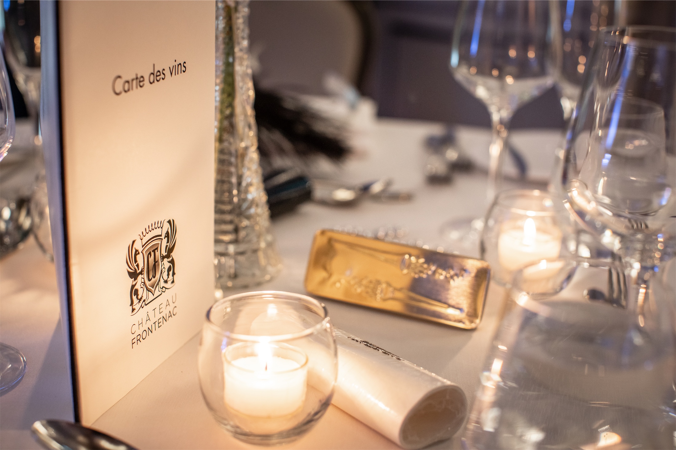 Candlelit dinner place setting and wine menu at Champlain
